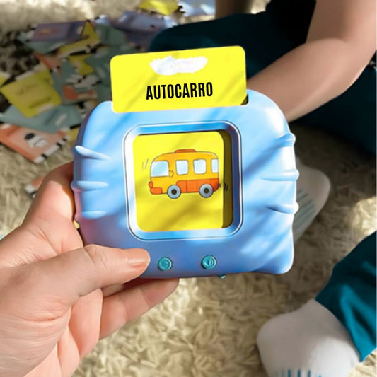 Mãos a segurar o leitor de cartões azul KinderSpeech com o cartão "Autocarro" inserido, demonstrando o brinquedo educativo para aprendizagem de vocabulário infantil.